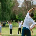a group of people doing yoga in a park